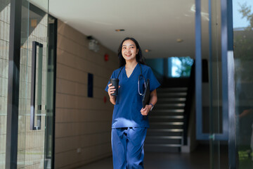 Asian medical professional leaving hospital with coffee