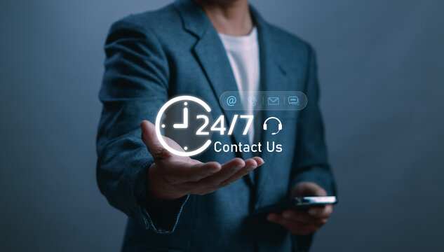 business professional presenting a glowing 24/7 contact support icon, symbolizing customer service, online assistance and nonstop communication for modern businesses in digital service environment