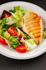 Grilled chicken breast salad chicken breast tomato, green leaf lettuce, salad mix snack vegetablestasty snack fresh gourmet food background on the table rustic top view copy space keto and paleo diet