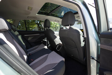 Hatch in car roof. Panoramic glass sun roof in the car. Clean glass and view from inside to the sky. Double sunroof hatch with tinted glass. Rear leather passenger seats in modern lux electric car