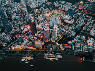 A city with a river running through it. There are many buildings and boats. The sky is dark and cloudy