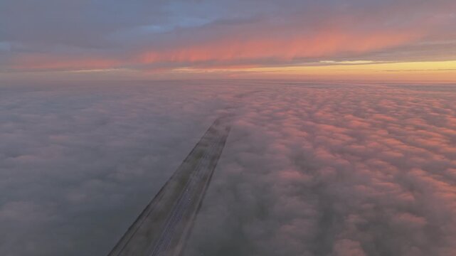 Aerial view of the Afsluitdijk road at sunrise, cutting through endless Dutch waters.
