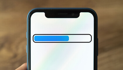 Closeup of a mobile phone displaying a loading bar on its screen. Represents progress, technology, connection, or anticipation. Useful for UIUX, app design.