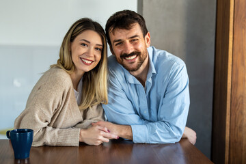 Happy and diverse couple sharing a joyful moment at home, embracing and smiling together
