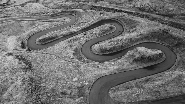 Aerial black and white view of a winding mountain road - Powered by Adobe