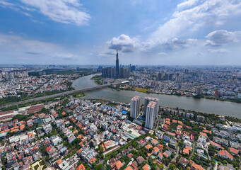 City with a river running through it. The river is surrounded by buildings. The sky is blue and there are clouds