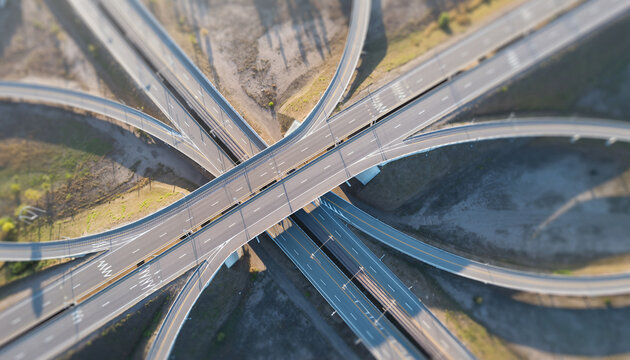 Aerial view of a complex highway interchange with a miniature tiltshift effect. Perfect for illustrating connectivity, infrastructure, transportation or complex systems.