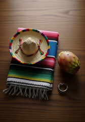 Traditional Mexican Sombrero, Serape, and Prickly Pear Fruit on a Wooden Table