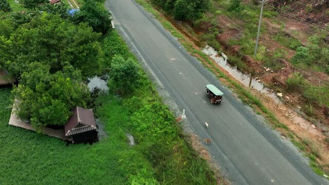 Traditional Asian Tuk Tuk is riding through the forest