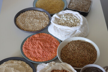 Bowls and bags full of various healthy grains and legumes. Selective focus.