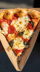 Takeaway pizza slice in triangular cardboard holder with toppings   