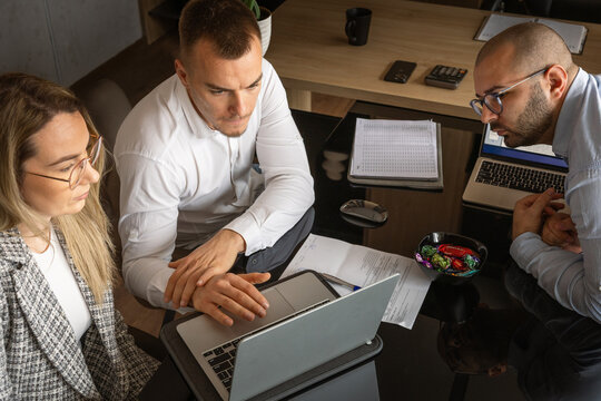 Business Office Meeting – Team Analyzing Data on Laptop