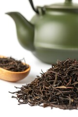 Fototapeta premium Green teapot and dry loose leaf black tea in wooden spoon and pile