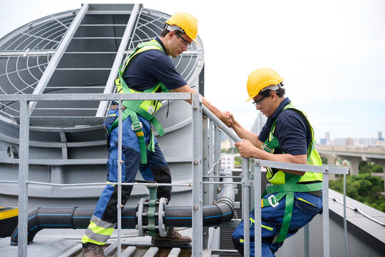Construction workers collaborating on a building's rooftop while wearing safety equipment, symbolizing teamwork, diligence, and focus