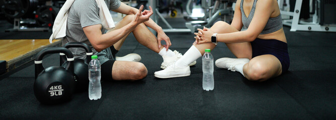 Fitness couple or friend having rest and talking, drinking water at gym