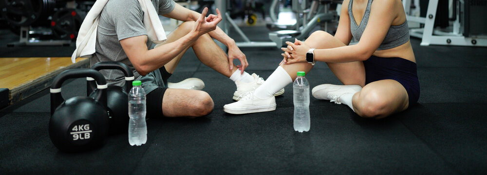 Fitness couple or friend having rest and talking, drinking water at gym - Powered by Adobe