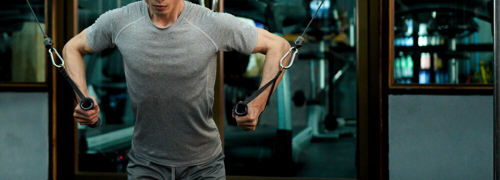 young man in the gym. a man is doing chest exercises using a cable machine in the gym. athlete exercise with cable crossover machine. cable crossover chest