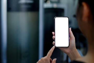 mockup hand holding a smartphone with transparent background with a gym blurred in the back