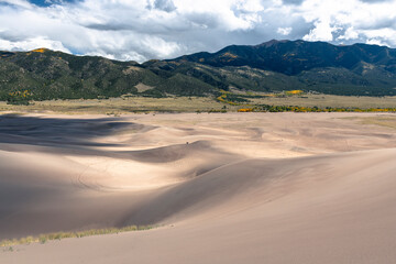 Sand dunes in front of green mountains