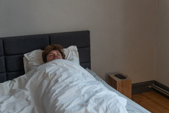 Man sleeping peacefully in his bed - Powered by Adobe