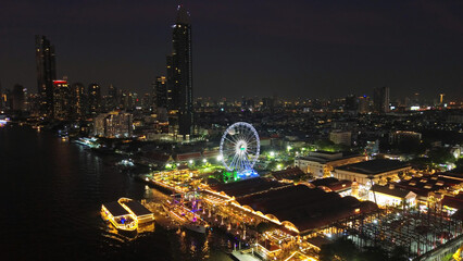 Fototapeta premium Skyscrapers and Ferris wheel in Bangkok city at night