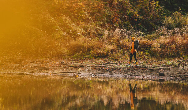 Woman Hiker Walking alone Riverbank during Autumn - Powered by Adobe