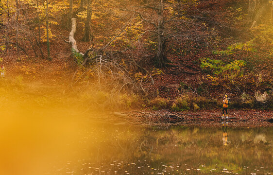 Woman Walking in Natural Landscape with Autumn Lake