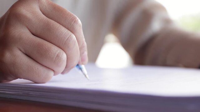 Close-up of a hand writing on paper, representing work, study, note-taking, focus, and productivity in a realistic and concentrated setting