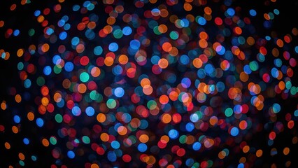 Colorful bokeh lights with vibrant orange, blue, and red hues creating an abstract, blurry pattern against a dark background.