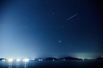 Milky way stars over ocean sea waters.