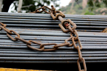 Heavy Steel Rods Secured with Chain for Construction Transport Safety