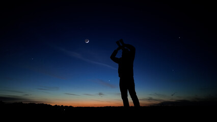 Amateur astronomer using binoculars for observing stars, planets, Moon and other celestial objects.