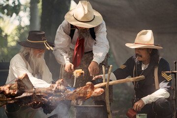 Group of cowboys preparing food at a campfire, roasting meat together in a warm