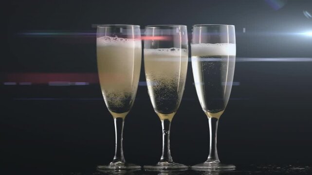 Three flutes with carbonation causing bubbles rising foam shifting glints forming for product ad