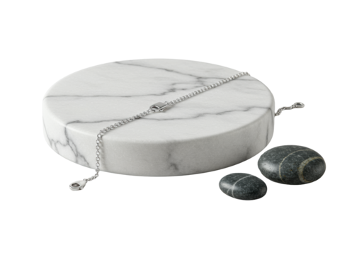 Macro shot: polished sterling silver chain bracelet draped on a white Carrara marble coaster with a dark river stone, seamless transparent background. Concept of refined elegance