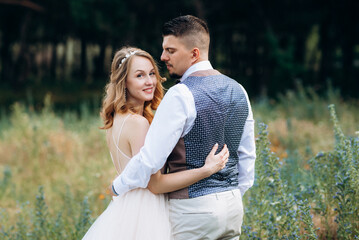 Fototapeta premium the bride and groom are walking in the park along the paths