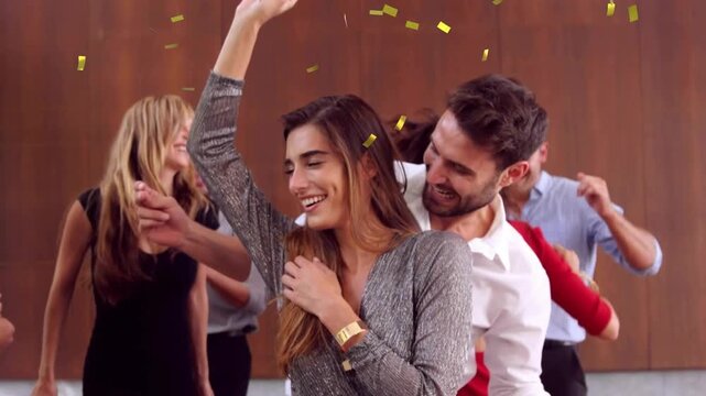 Female guest dancing with male partner as confetti falling and landing, celebrating event