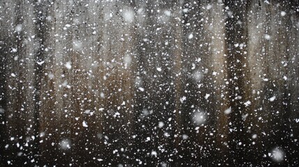 Fototapeta premium Falling snowflakes slowly accumulating on a dark textured surface