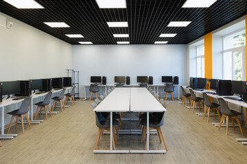 Modern workspace filled with computers and sleek furniture in a bright, spacious setting