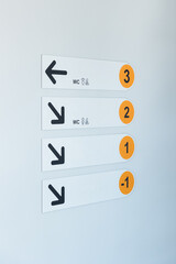 Clear directional signs guide visitors through a multi-level building to facilities