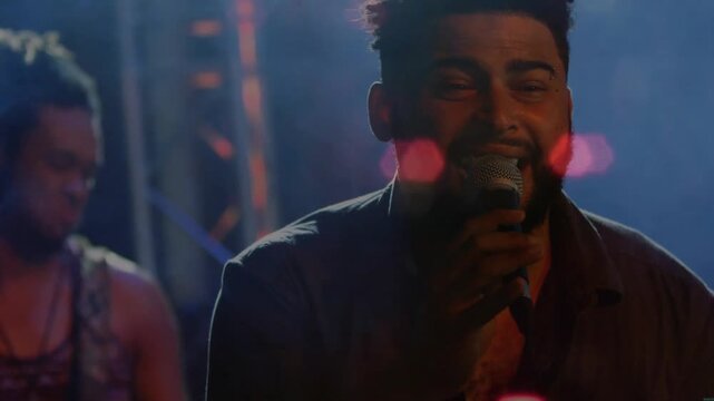 Lead vocalist starting song in music set, projecting vocals moving crowd, bokeh pulsing over singer