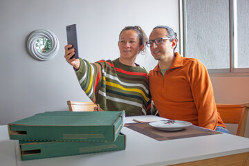 Couple taking a selfie with smartphone at home