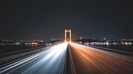 Bridge illuminated at night, showing long exposure light trails of vehicles moving swiftly across the structure, with a glowing cityscape and water body along the horizon