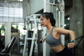 Fototapeta premium A woman exercise chest workout on cable chest press machine, Fitness and workout concept