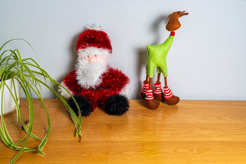Woollen Santa Claus and reindeer toy on a cabinet in a Christmas scene