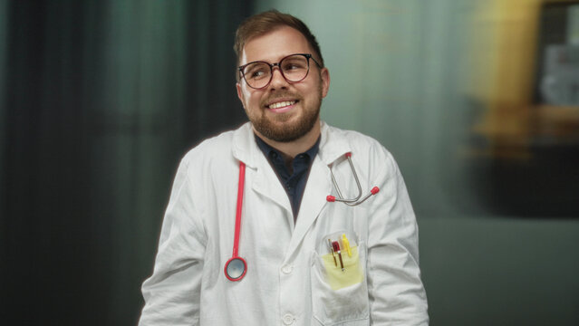 Man doctor with stethoscope smiling in building train station platform, white coat and glasses visible; friendly care and reassurance.