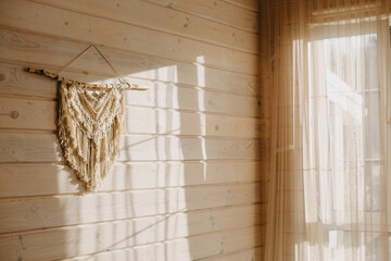 Macrame on the wall of a wooden house.