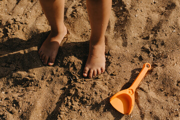 Children's feet in the sand on the beach.