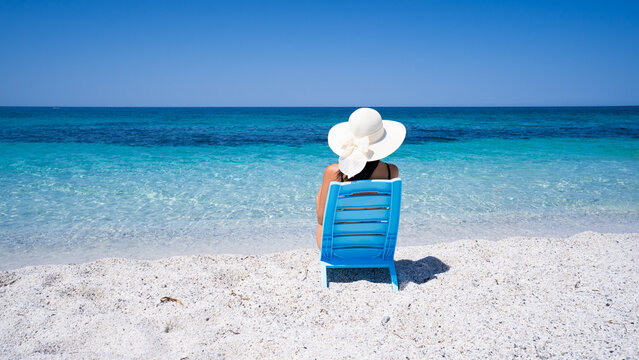 Hand holding quartz sand grains from Is Arutas beach