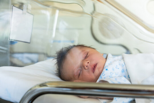 Newborn baby sleeping in hospital incubator for care